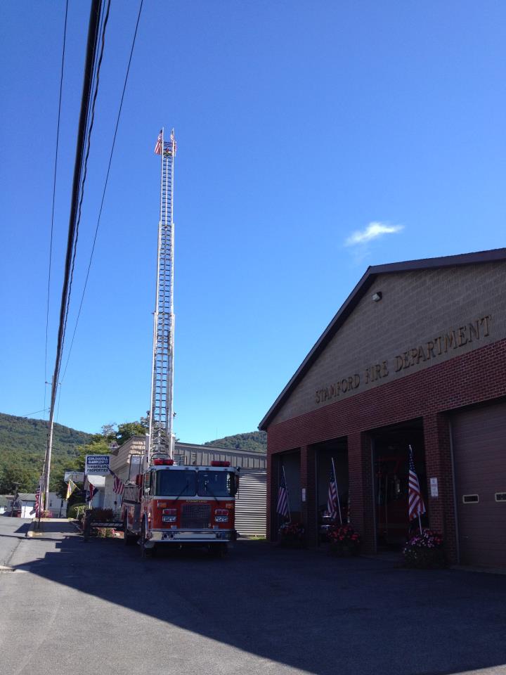 ladder truck in the front of the fire house